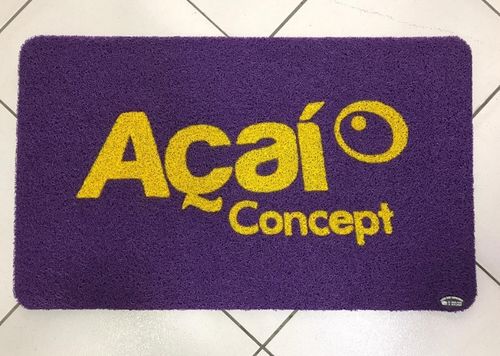 Capacho personalizado roxo com a logomarca Açaí Concept em letras amarelas, textura de fibra colorida vibrante, fotografia realista de tapete comercial personalizado